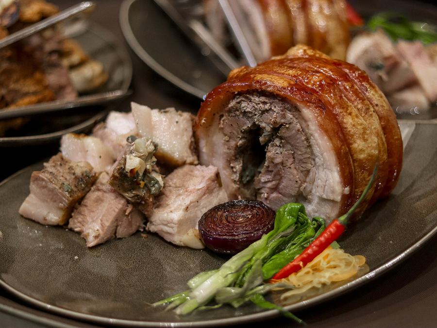 Sliced lechon belly with crackling skin on a platter