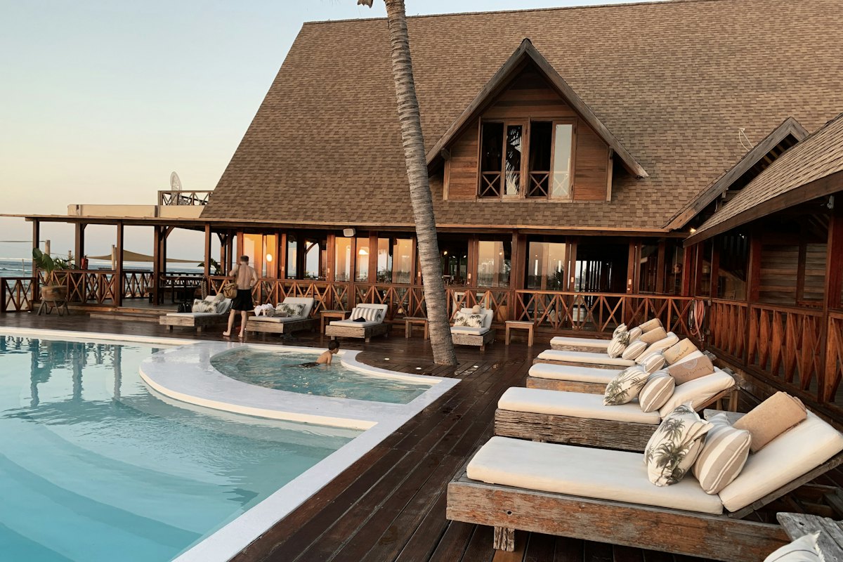 Sample photo: a pool deck with loungers beside a wooden lodge